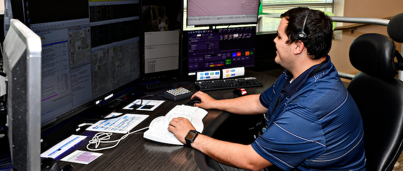 Photo of male dispatcher sitting at desk watching computer