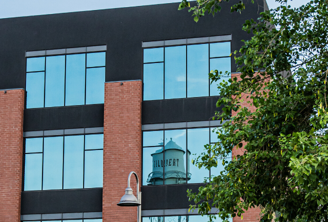 A view of a building in downtown Gilbert shows a reflection of the Gilbert Water Tower.