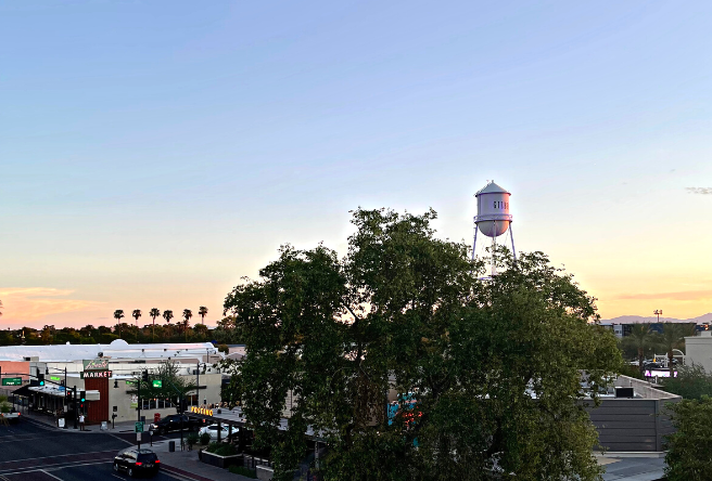 A view of downtown Gilbert at sunset. The Gilbert Water Tower stands just above the trees.