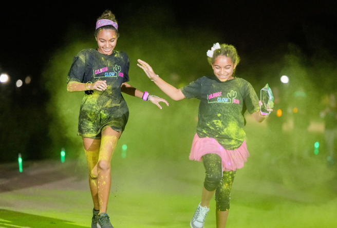 Two runners cross the finish at the 2021 Gilbert Glow Run.