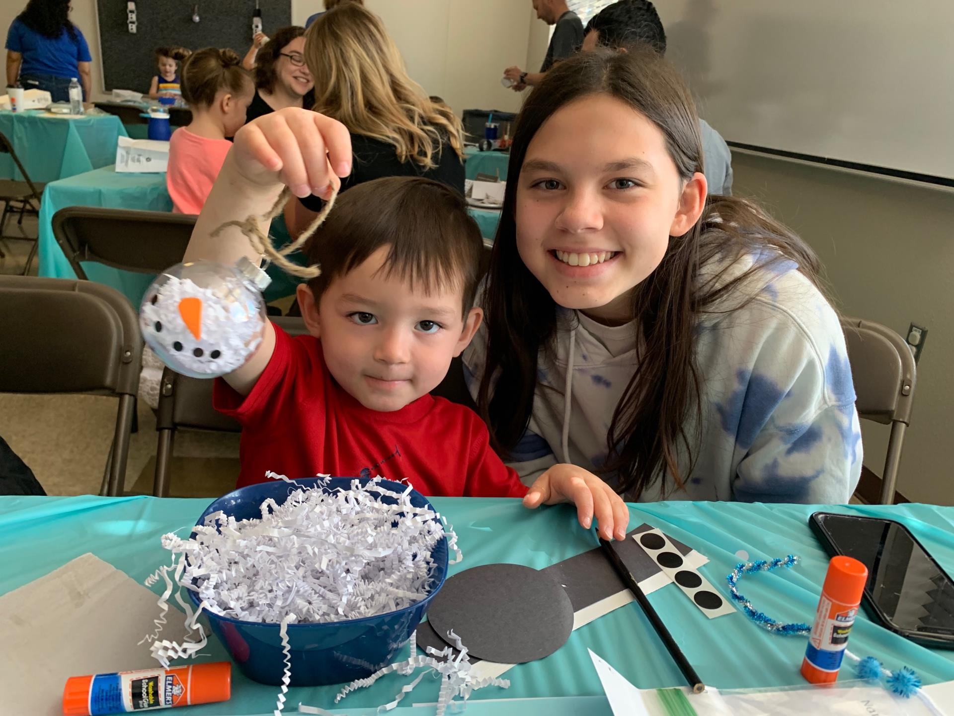 Two people create a Christmas ornament together