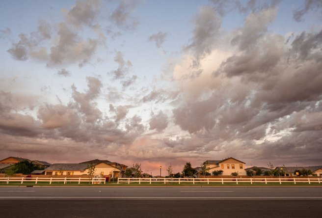 A photo of a Gilbert neighborhood with clouds hovering above the rooftops.