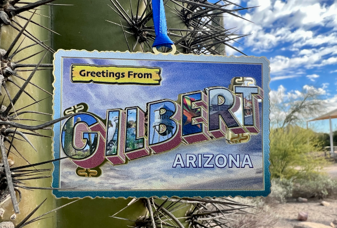 A postcard ornament reads: Greetings from Gilbert. Purchase it at the Gilbert Goodies Store.