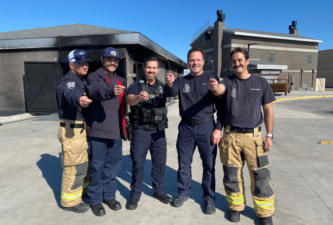 Firefighters and a police officer holding sparklers.