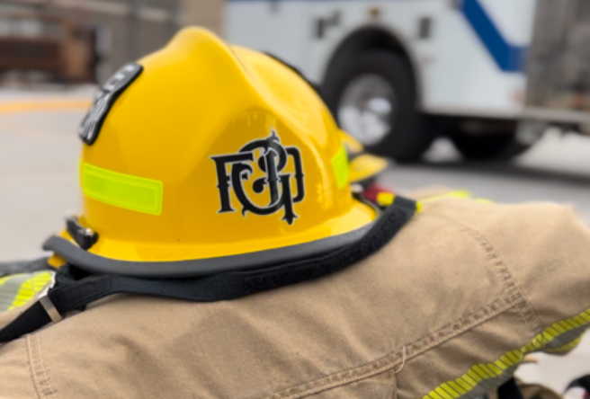 A yellow Gilbert Fire & Rescue Department helmet sitting on top of a firefighter turnout coat.