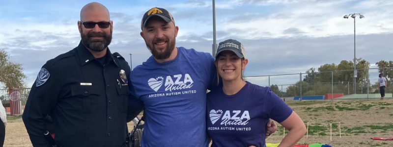 Smiling officer with two community members 