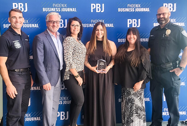 A group of Gilbert employees with an award from the Phoenix Business Journal