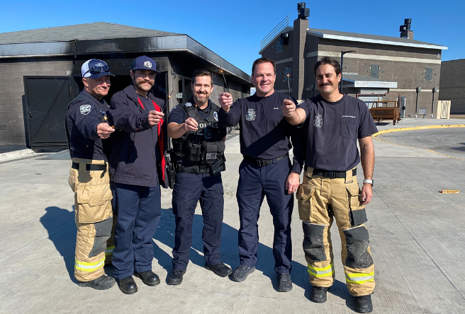 A photo of Gilbert firefighters and police officers holding sparklers, one of the permissible fireworks during this time of year.