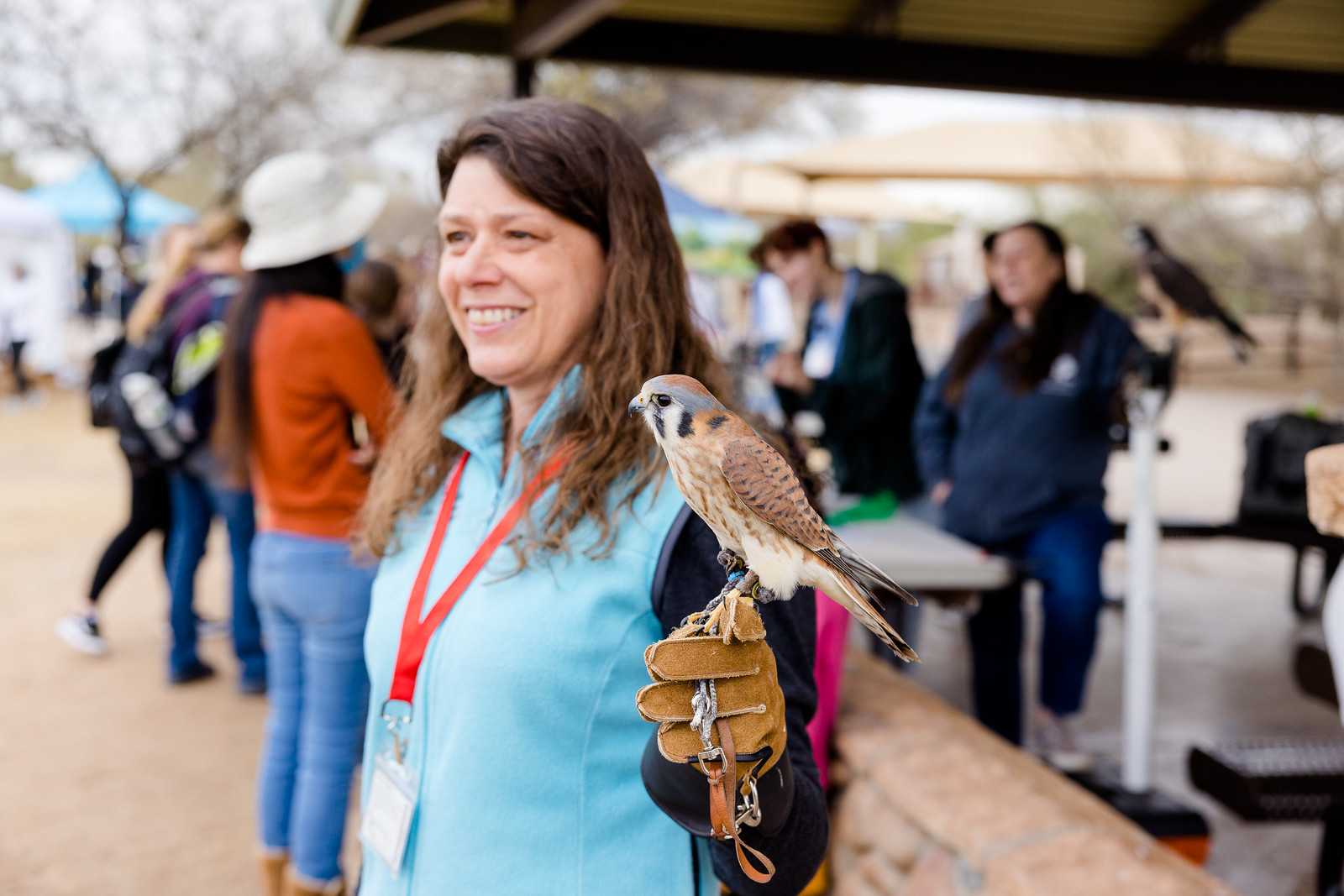 This is a photo of a woman holding a bird on display. 