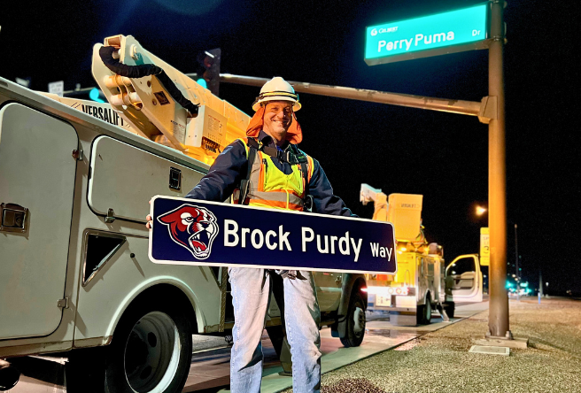 A member of Gilbert's Public Works Department holds up an Brock Purdy Way sign prior to installation.