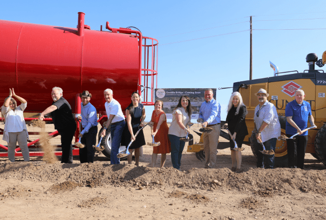 A wide shot of the Gilbert Town Council, Town Manager and an Assistant Town Manager breaking ground at the Ocotillo Bridge construction site.