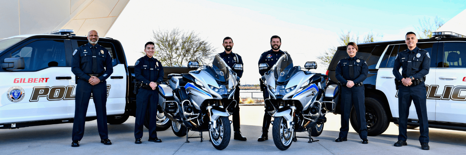 A group of Gilbert Police officers pose next to police cruisers and motorcycles at Gilbert Regional Park.