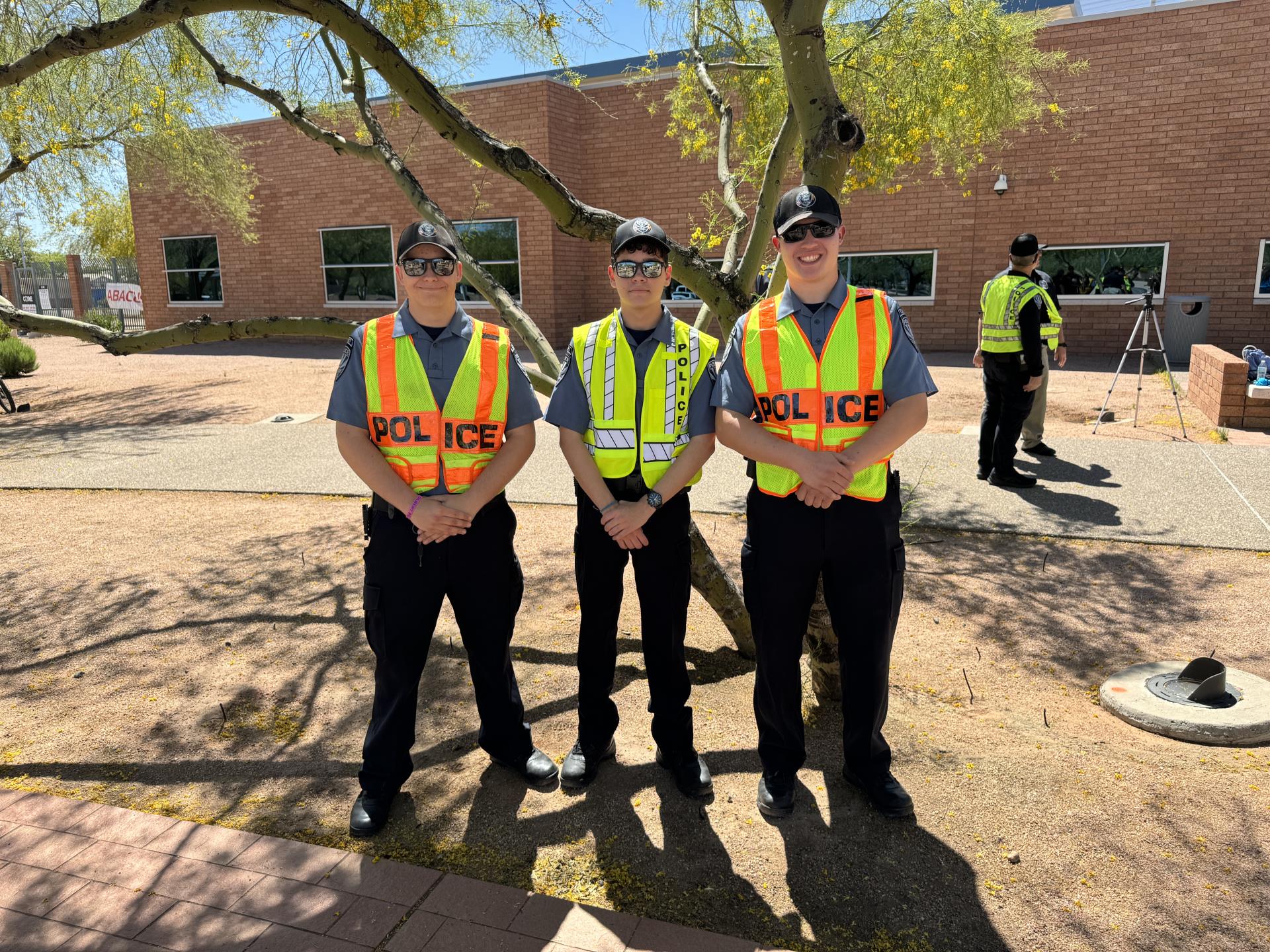 Three police cadets smile at the camera