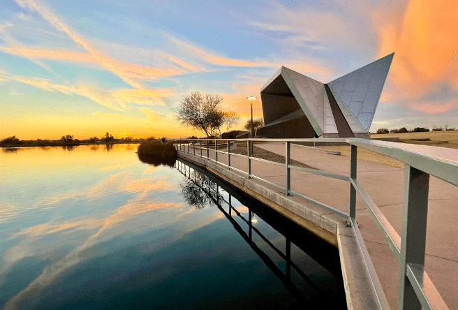 A medium shot of Gilbert Regional Park showing the amphitheater and lake at sunset.