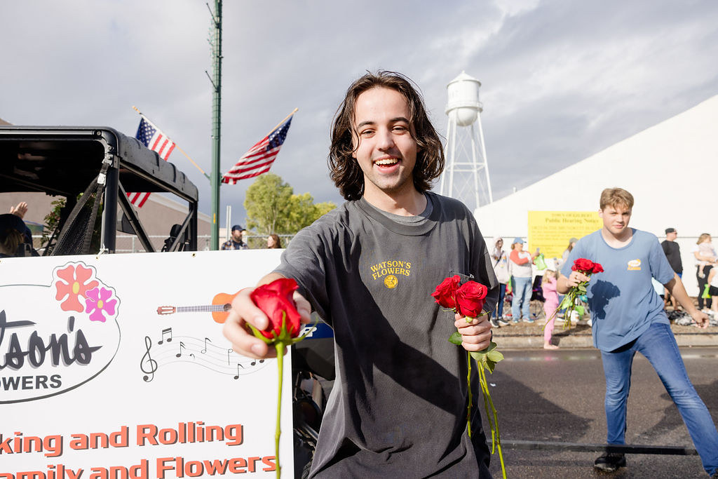 A photo of a man passing out roses at the Gilbert Day parade